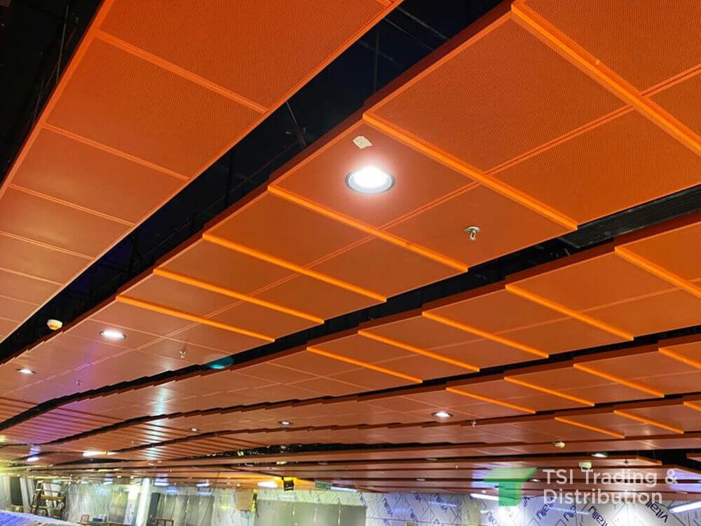 A close up view of KNAUF Ceiling Solutions Armstrong Metalworks Clip-In ceiling tiles in orange colour near the shop lots
