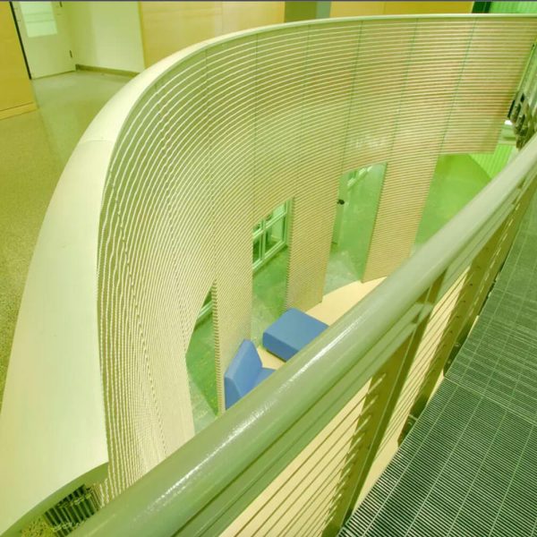 GKD Sambesi flexible mesh applied as a curved wall that extends to become the balustrade of a railing system.